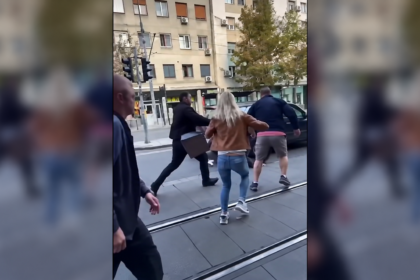 People gathered beside tram tracks during a street confrontation in Belgrade.