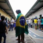 Editorial illustration of Brazilian voters approaching a polling station in Brasília, with Brazil's flag at sunset